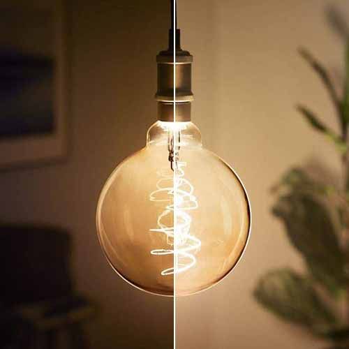 PHILIPS Vintage Ampoule LED filament dimmable E27 230V 7W(=40W) 470lm 1800K LEDbulb Giant globe - photo de l'ampoule avec deux variations de lumière différentes
